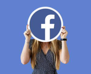 Woman showing a Facebook icon